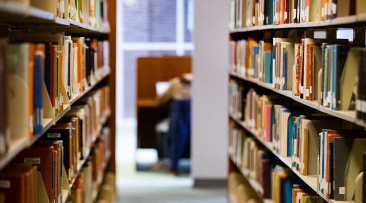 an aisle between two library bookshelves